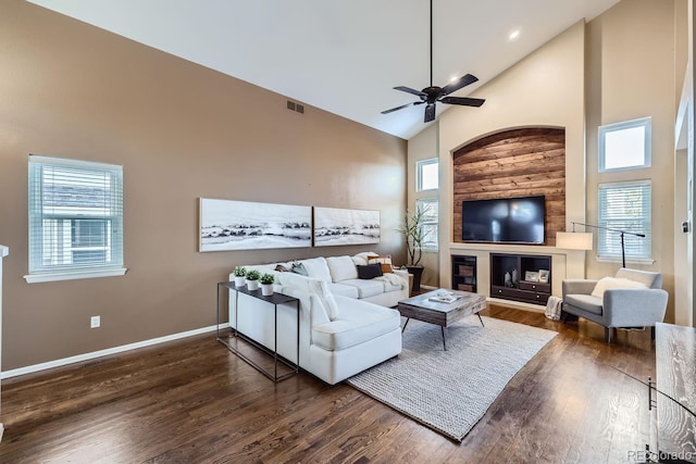 living room with ceiling fan, dark hardwood / wood-style floors, and high vaulted ceiling