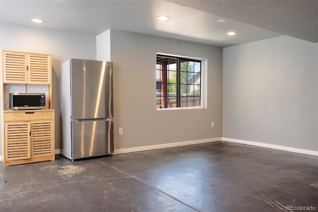 kitchen with stainless steel appliances, finished concrete flooring, baseboards, and recessed lighting