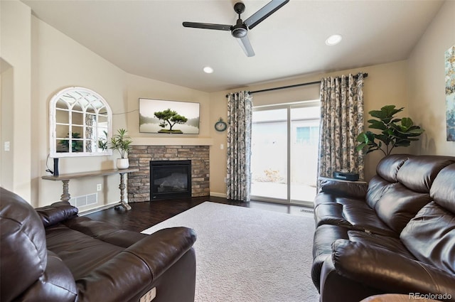 living room with ceiling fan, a fireplace, wood-type flooring, and vaulted ceiling