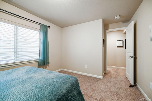 bedroom with light carpet and multiple windows