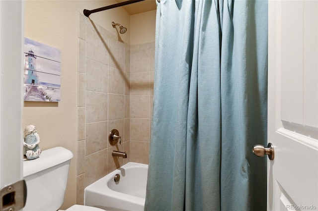 bathroom featuring shower / bath combo and toilet