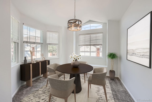 carpeted dining area featuring a notable chandelier and a healthy amount of sunlight