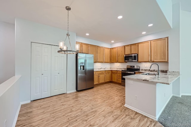 kitchen featuring an inviting chandelier, light hardwood / wood-style flooring, appliances with stainless steel finishes, light stone counters, and kitchen peninsula