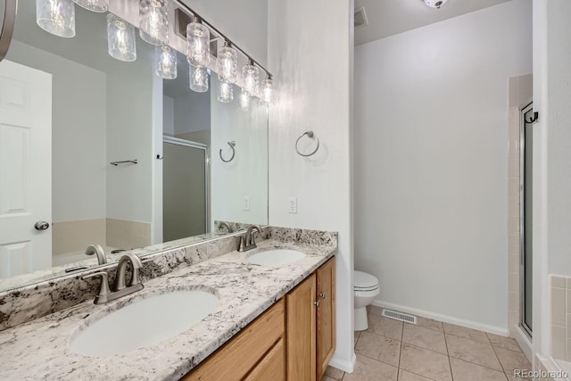 bathroom featuring vanity, toilet, tile patterned flooring, and a shower with door