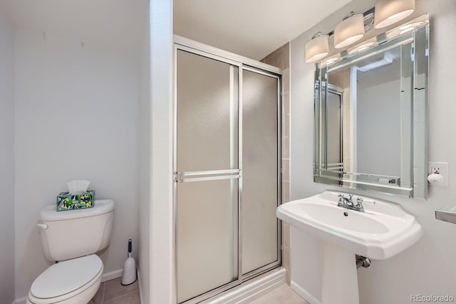 bathroom with tile patterned flooring, a shower with shower door, and toilet