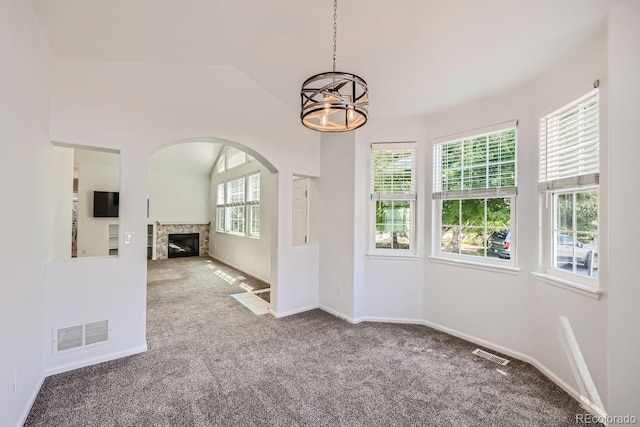 interior space with lofted ceiling, a notable chandelier, and carpet flooring