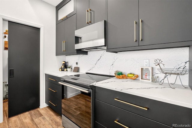 555 Sunrise Peak Rd, Manitou Springs, CO 80829 - kitchen featuring stainless steel electric range, white microwave, tasteful backsplash, light wood-style floors, and light stone countertops
