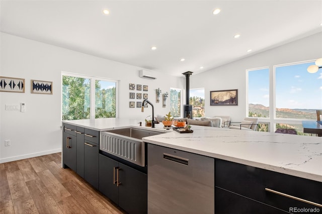 555 Sunrise Peak Rd, Manitou Springs, CO 80829 - kitchen with stainless steel dishwasher, a wood stove, a wall mounted AC, recessed lighting, and light wood-style flooring