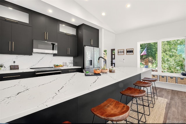 555 Sunrise Peak Rd, Manitou Springs, CO 80829 - kitchen featuring white microwave, dark cabinetry, refrigerator with ice dispenser, electric range, and vaulted ceiling
