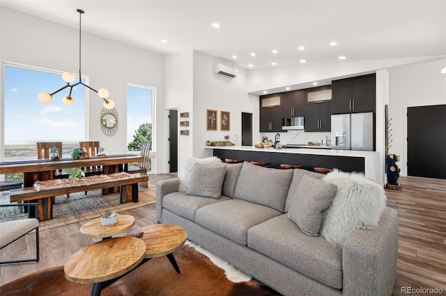 555 Sunrise Peak Rd, Manitou Springs, CO 80829 - living area with a chandelier, recessed lighting, light wood-type flooring, an AC wall unit, and a towering ceiling