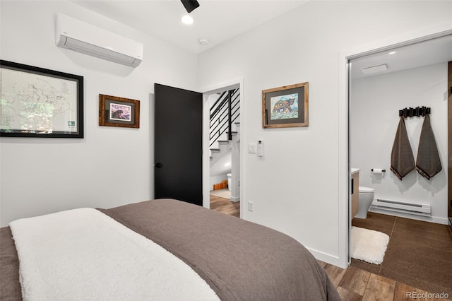 555 Sunrise Peak Rd, Manitou Springs, CO 80829 - bedroom with a wall unit AC, baseboard heating, dark wood-style floors, connected bathroom, and recessed lighting