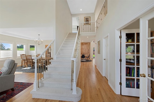 25 Sand Cherry, Littleton, CO 80127 - stairs featuring wood finished floors, a towering ceiling, a chandelier, and recessed lighting