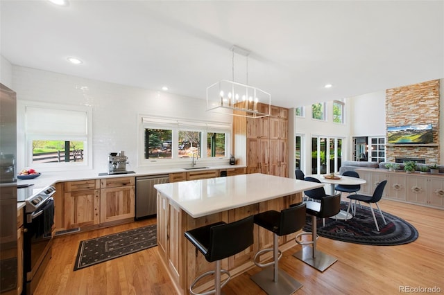 25 Sand Cherry, Littleton, CO 80127 - kitchen with stainless steel appliances, light wood-style flooring, light countertops, a kitchen breakfast bar, and recessed lighting