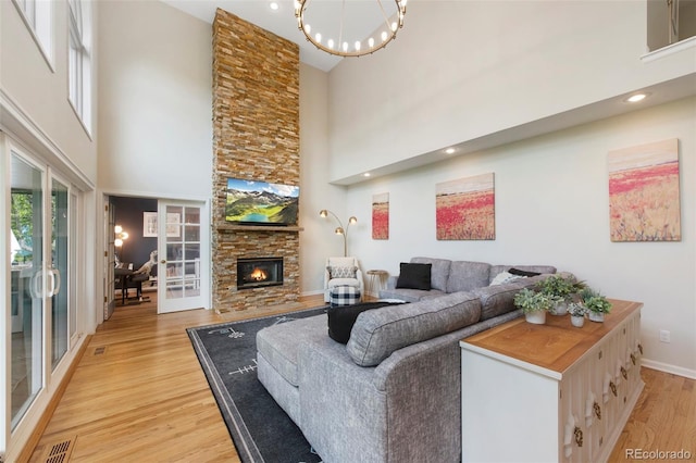 25 Sand Cherry, Littleton, CO 80127 - living area with a high ceiling, light wood-style flooring, a stone fireplace, french doors, and recessed lighting