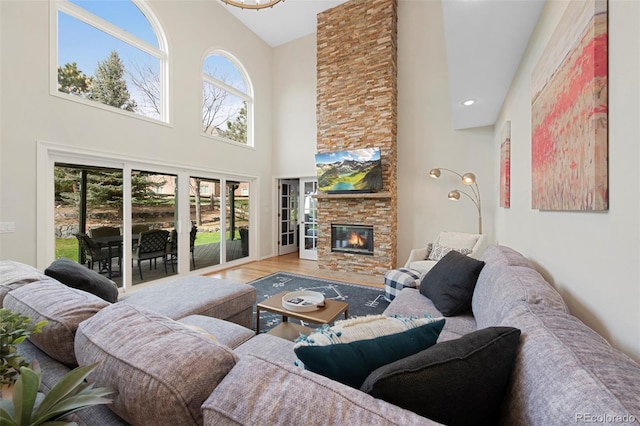 25 Sand Cherry, Littleton, CO 80127 - living room featuring a high ceiling, plenty of natural light, a stone fireplace, and wood finished floors