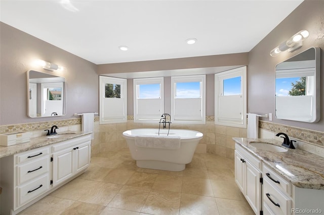 25 Sand Cherry, Littleton, CO 80127 - bathroom featuring tile walls, two vanities, a freestanding bath, wainscoting, and tile patterned flooring