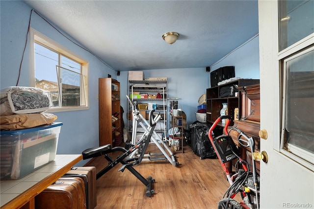 exercise area featuring a textured ceiling and hardwood / wood-style floors