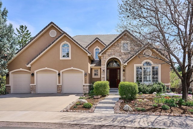 view of front of property featuring stone siding, stucco siding, concrete driveway, an attached garage, and a tile roof
