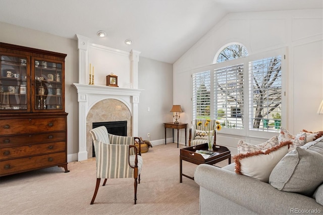 living area featuring a premium fireplace, high vaulted ceiling, and light carpet