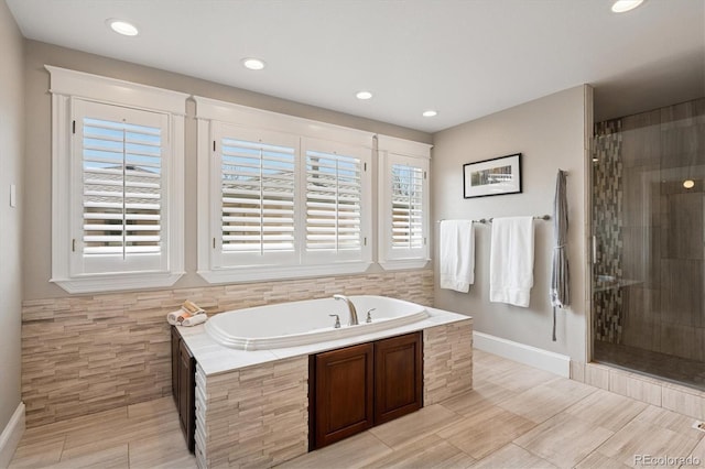 bathroom featuring baseboards, a garden tub, recessed lighting, and tiled shower
