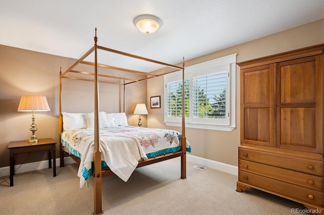 bedroom with baseboards, light carpet, and visible vents