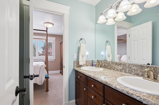 ensuite bathroom with a sink, ensuite bath, and double vanity