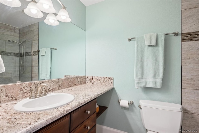 full bath featuring toilet, baseboards, a tile shower, and vanity
