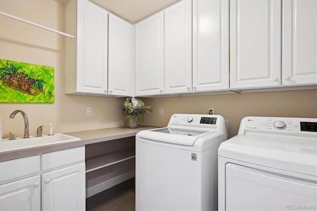 laundry area featuring cabinet space, a sink, washer and clothes dryer, and tile patterned flooring