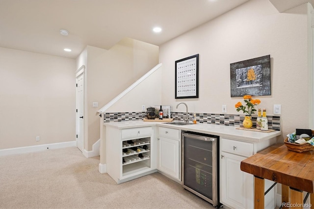 bar with beverage cooler, a sink, light carpet, and tasteful backsplash