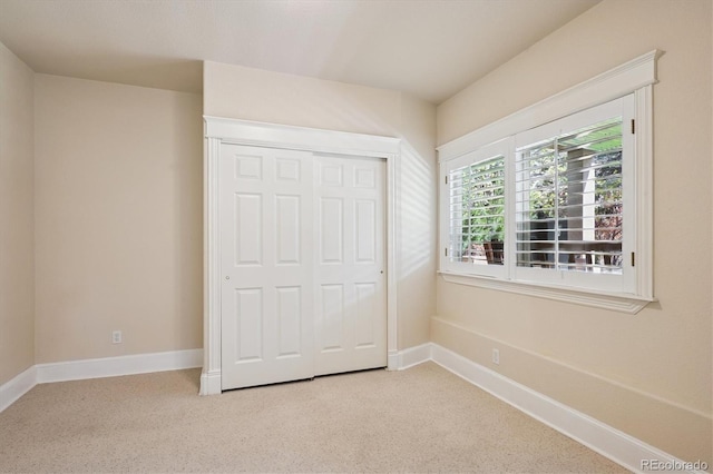 unfurnished bedroom featuring carpet flooring, baseboards, and a closet