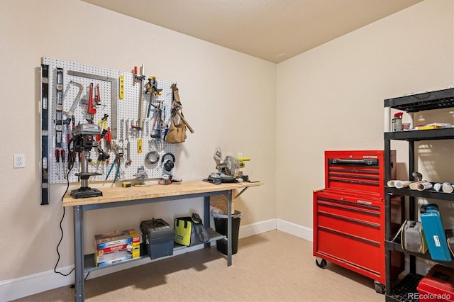 misc room featuring baseboards and a workshop area