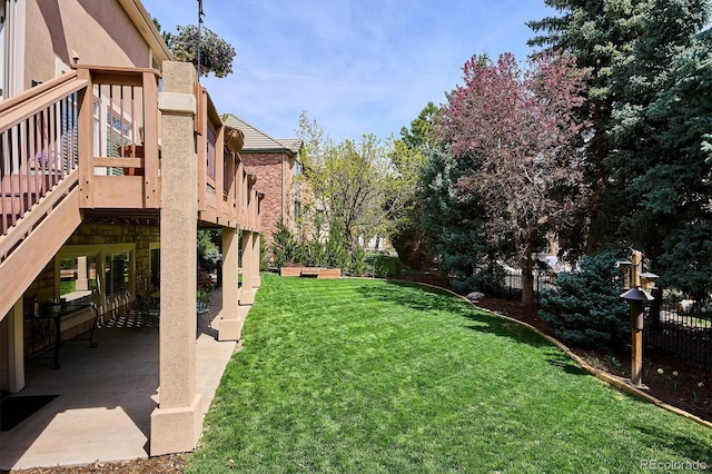 view of yard featuring fence, a wooden deck, and a patio area