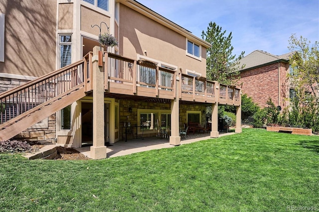 back of property with a lawn, a patio area, stone siding, and a deck