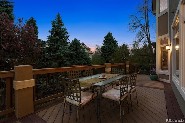 deck at dusk with outdoor dining space