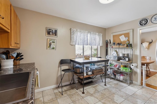 dining space featuring baseboards and light tile patterned floors