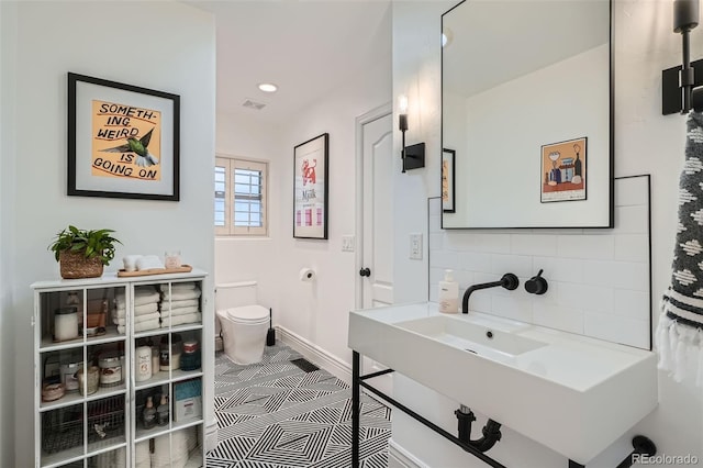 bathroom featuring baseboards, visible vents, recessed lighting, decorative backsplash, and toilet