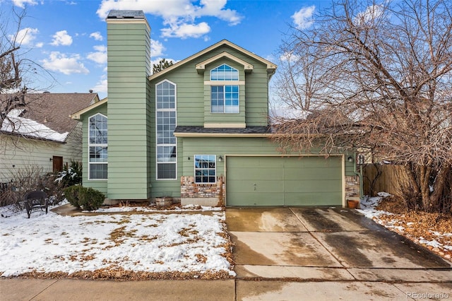 view of front of house featuring a garage, a chimney, fence, and concrete driveway