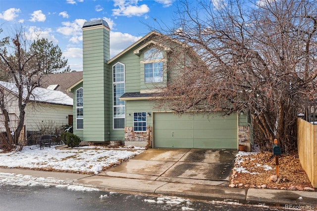 traditional-style home with concrete driveway, fence, a chimney, and an attached garage