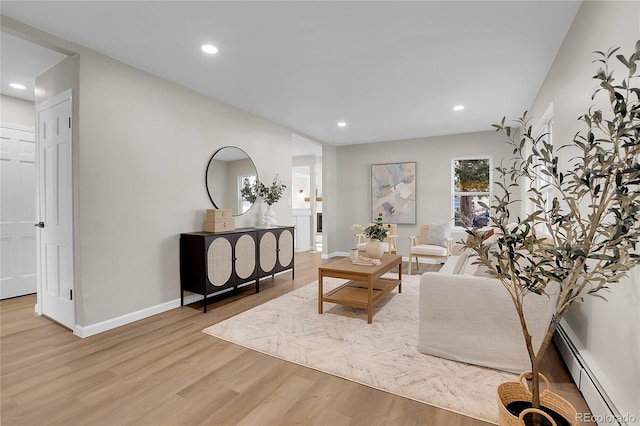 living room featuring baseboard heating and light hardwood / wood-style flooring