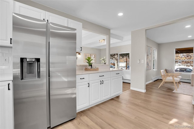 kitchen with white cabinets, a baseboard heating unit, stainless steel fridge with ice dispenser, and light hardwood / wood-style floors