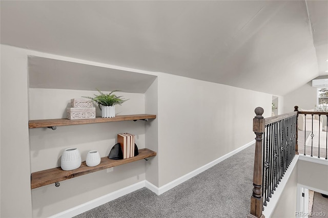 hallway with carpet flooring and vaulted ceiling