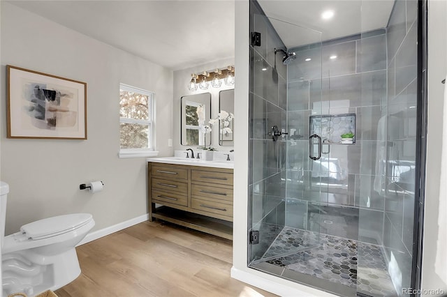 bathroom featuring an enclosed shower, vanity, toilet, and hardwood / wood-style flooring