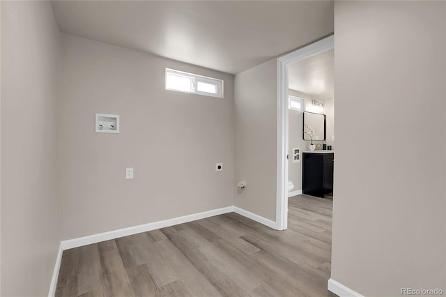 laundry area with light hardwood / wood-style floors, hookup for a washing machine, and electric dryer hookup