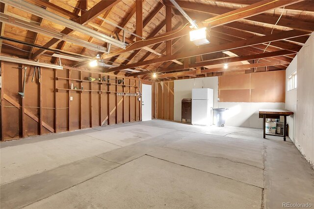 garage featuring white fridge and a garage door opener