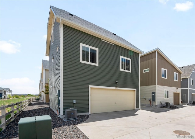 17767 E 54th Ave, Denver, CO 80249 - back of house featuring fence, driveway, an attached garage, and cooling unit