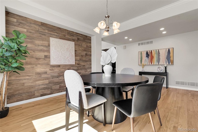 3406 Purcell St, Brighton, CO 80601 - dining area featuring a chandelier, baseboards, wooden walls, crown molding, and light wood-style flooring