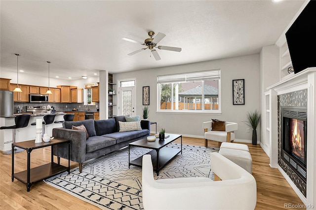 3406 Purcell St, Brighton, CO 80601 - living area with a fireplace, light wood-type flooring, ceiling fan, baseboards, and recessed lighting