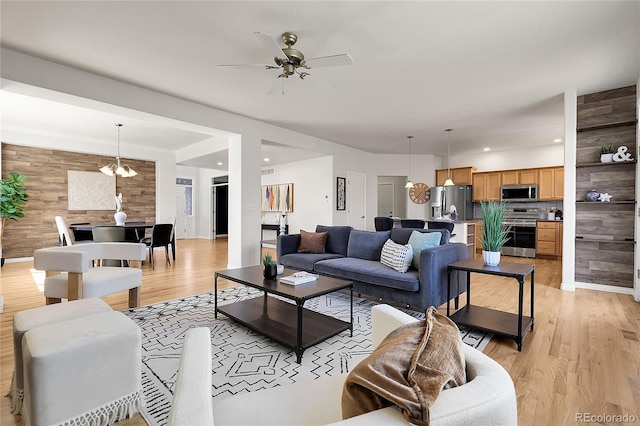 3406 Purcell St, Brighton, CO 80601 - living room with wood walls, light wood-style floors, ceiling fan, recessed lighting, and a chandelier