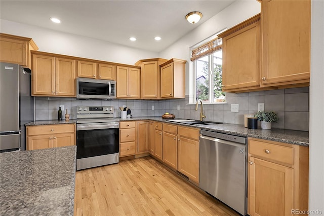 3406 Purcell St, Brighton, CO 80601 - kitchen with appliances with stainless steel finishes, a sink, light wood-style flooring, tasteful backsplash, and recessed lighting