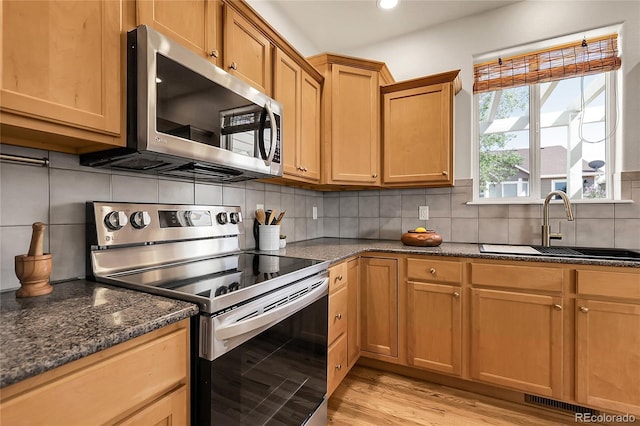 3406 Purcell St, Brighton, CO 80601 - kitchen with appliances with stainless steel finishes, a sink, backsplash, light wood-style floors, and recessed lighting